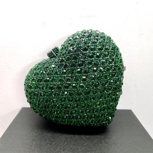 Detailed view of heart-shaped clutch bag with emerald green crystals and metal clasp