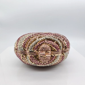 Pink and white rhinestone crystal evening clutch bag with gold clasp on pedestal