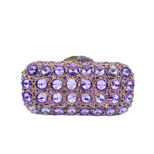 Close-up of luxury purple rhinestone evening clutch with gold metal frame and jewel clasp