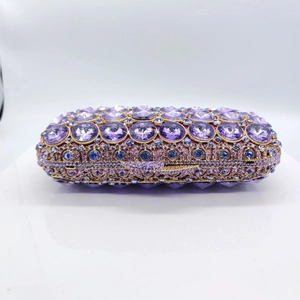Detailed macro view of purple rhinestones and blue gemstones on a luxury evening clutch bag