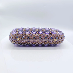 Detail of a luxury clutch bag featuring multi-tone purple and pink wave pattern rhinestones