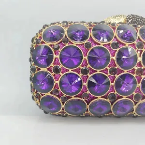 Close-up of deep purple faceted crystals and glitter fabric on luxury evening bag