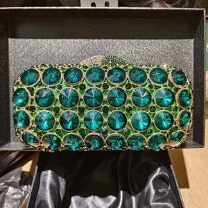 Detailed view of luxury emerald green crystal evening clutch with gold metal frame