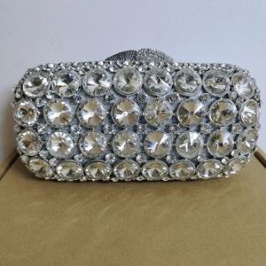 Close-up of luxury silver rhinestone clutch with large crystals and metallic snap closure