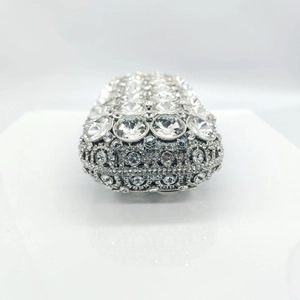 Macro shot of silver rhinestone evening bag with large central crystal and detailed inlay