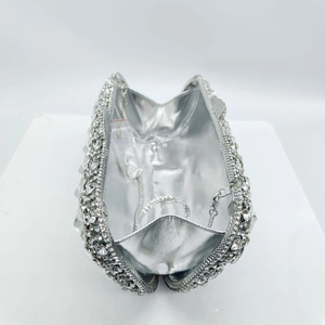 Interior view of silver rhinestone clutch showing shiny lining and metal chain strap