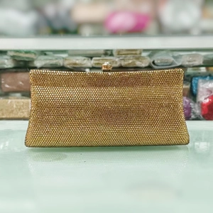 Detail of luxury golden rhinestone evening clutch bag with ornate jewel-encrusted clasp