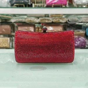 Detailed close-up of a red luxury rhinestone clutch bag with shimmering crystal clasp