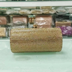 Macro shot of luxury cylindrical gold rhinestone clutch bag with sparkling crystal details