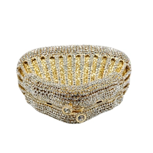 Detail of a shell-shaped rhinestone evening bag with gold metal base and crystal clasp