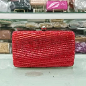 Detailed macro view of vibrant red rhinestone evening clutch bag with crystal buckle