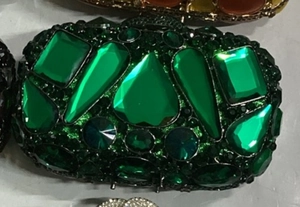 Détail macro d'une pochette de soirée vert émeraude avec cristaux et pierres fines