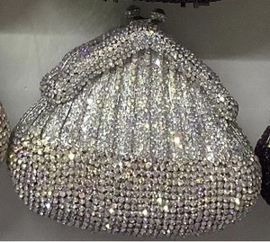 Detail of silver rhinestone evening bag featuring shell shape and crystal sphere clasp