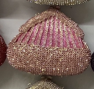 Detailed macro view of the sparkling pink rhinestone pattern on the seashell evening clutch