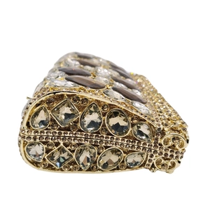 Dettaglio degli strass champagne e della montatura metallica traforata della pochette
