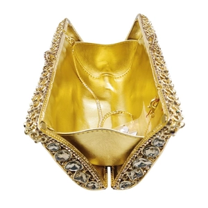 Dettaglio interno della pochette da sera dorata con strass e catena in metallo dorato