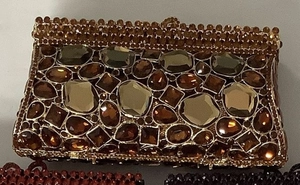 Dettaglio macro della borsa da sera con strass ambra, cornice metallica e cristalli