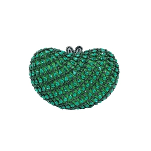 Macro shot of dark green heart-shaped clutch bag with sparkling rhinestone crystals