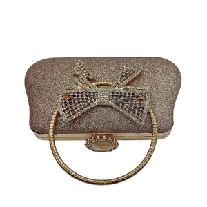 Elegant champagne gold sequin clutch bag with large rhinestone bow and ring handle