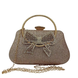 Detail of rose gold glitter evening clutch with rhinestone bow and ring handle