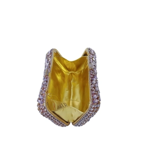 Macro view of lavender rhinestone clutch showing golden metallic lining and luxury texture