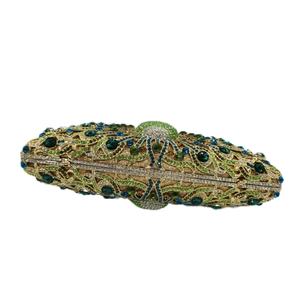 Macro view of crystal encrusted peacock pattern on a gold luxury evening clutch bag