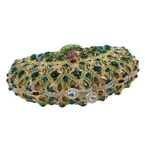 Detailed close-up of emerald and sapphire rhinestone patterns on luxury peacock evening bag
