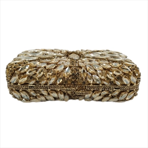 Close-up of luxury champagne gold evening clutch with intricate leaf-shaped crystals
