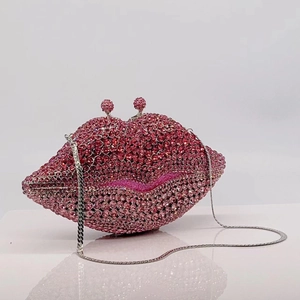 Detailed view of pink rhinestone-encrusted lip evening clutch with silver chain strap