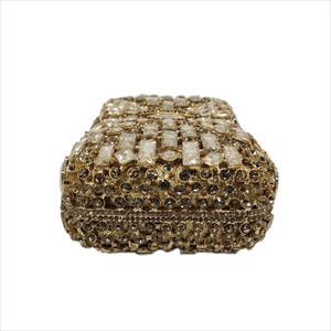 Close-up of golden evening clutch featuring sparkling rhinestones and crystal inlay details