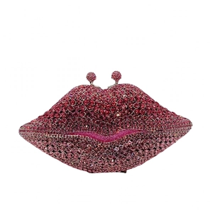 Detail of red lip-shaped evening clutch bag featuring gradient rhinestones and dual sphere clasp