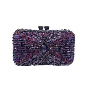 Close-up of a purple evening clutch bag with intricate crystal rhinestones and metal clasp
