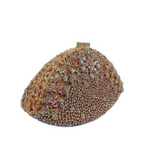 Macro view of gold-tone evening clutch featuring intricate crystal floral patterns and metal clasp