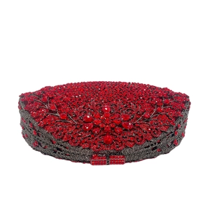 Close-up of sparkling red rhinestones and hollow floral metal patterns on evening clutch