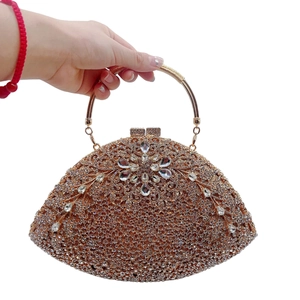 Close-up of a crescent-shaped champagne gold evening clutch with radiant crystal flowers