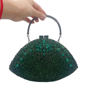 Detail of dark green evening clutch with emerald crystals and rhinestone flower pattern