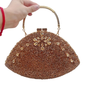 Detail of evening clutch featuring fan shape with crystals and metallic handle
