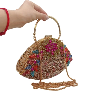 Macro detail of wisteria floral crystal clutch with gold ring handle and chain