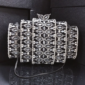 Macro shot of tiered black evening clutch with crystal inlay and silver bow clasp