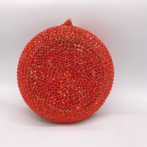 Close-up of red rhinestone evening clutch bag with elegant golden triangular metal clasp