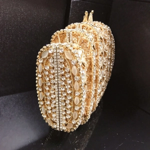 Macro detail of luxury gold evening clutch with white gems and sparkling crystals