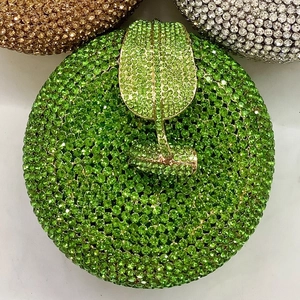 Detail of green crystal apple clutch bag with a golden metal leaf clasp closure
