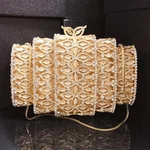 Macro detail of luxury evening clutch showing white synthetic cat eye stones and rhinestones