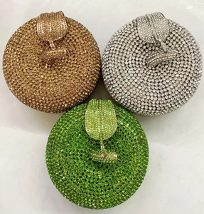Detailed overhead view of round crystal-studded apple clutch bags in gold, silver, and green