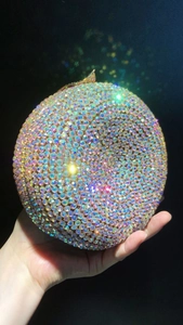 Close-up of a spherical evening clutch bag with iridescent AB rhinestones and metal clasp