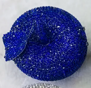 Macro detail of sparkling royal blue rhinestones on a luxury evening apple clutch bag