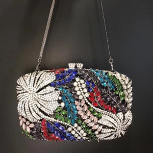 Détail de la pochette hibiscus ornée de strass multicolores et d'une chaîne en métal argent