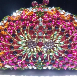 Détail macro de la pochette de soirée de luxe avec cristaux colorés et motif plume de paon