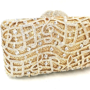 Close-up of golden musical note evening clutch bag with intricate rhinestone embellishments