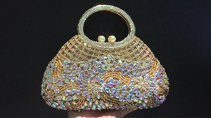 Detail of luxury gold dinner clutch with colorful crystals, rhinestones and pearl clasp